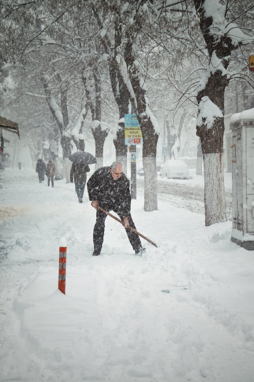 Sunday. Aman shoveling the snow on the street